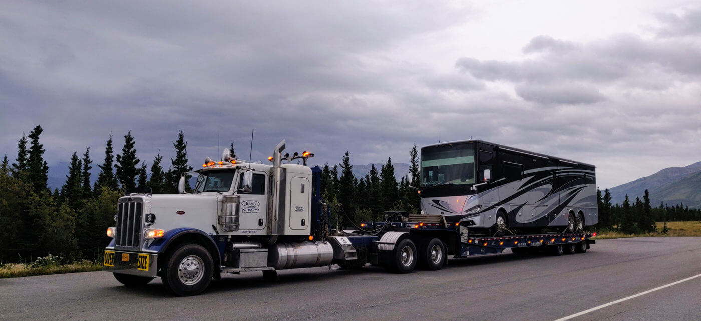 Ben's Towing truck towns motorcoach down Alaskan highway.